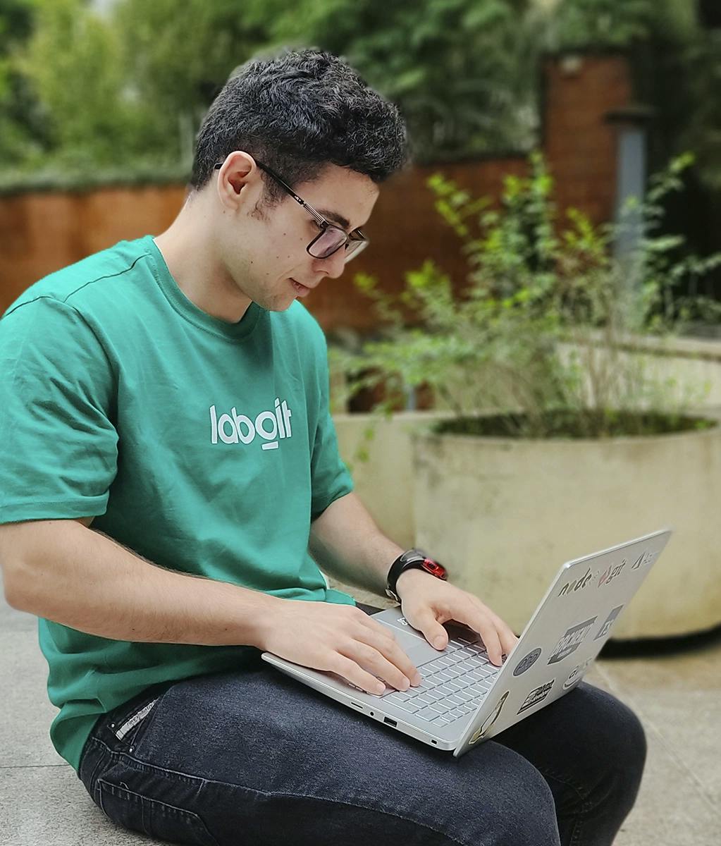 Luis Eduardo, backend engineer at Laborit, working on the outside of our glass house.